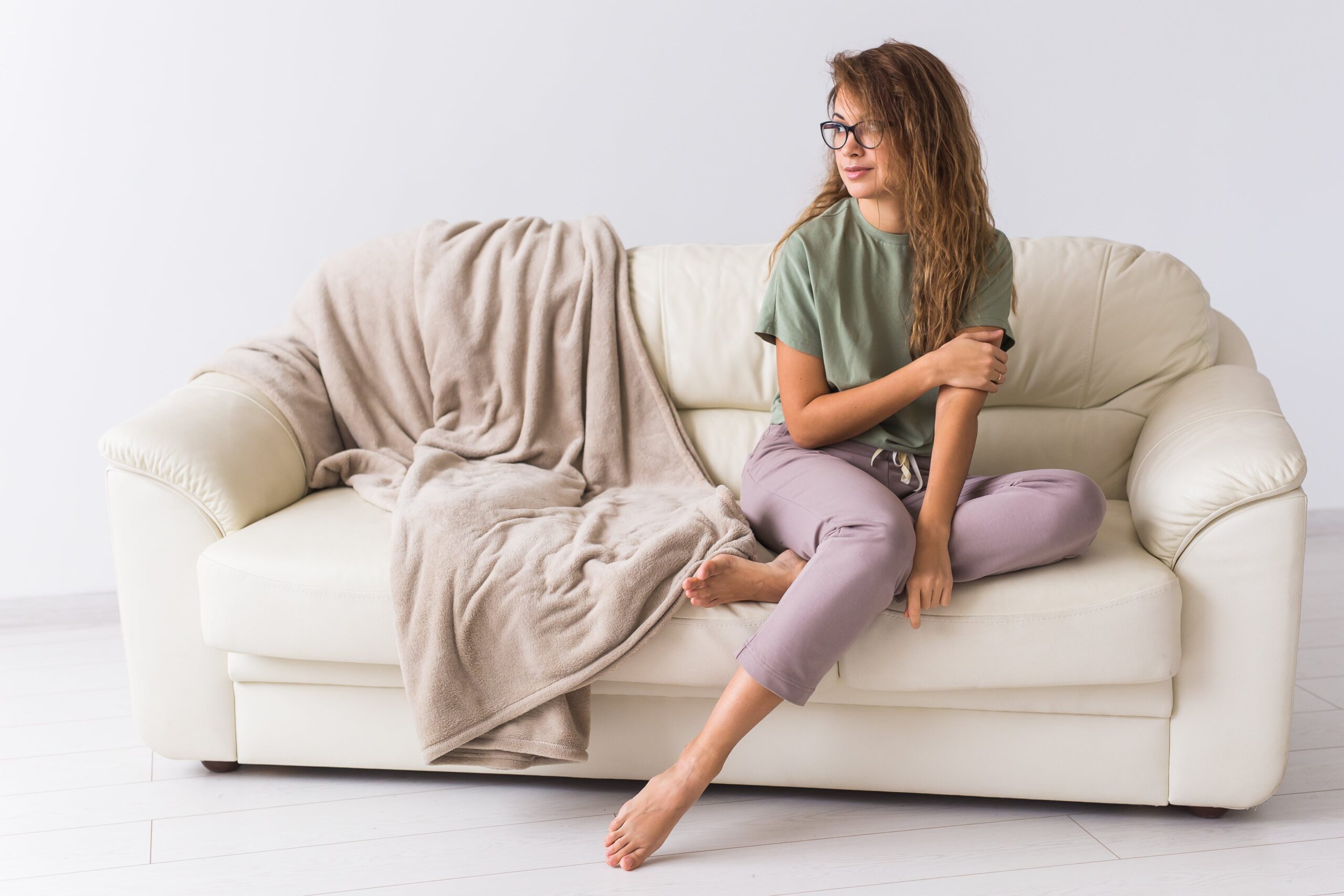 young-woman-using-laptop-while-sitting-sofa-home-min